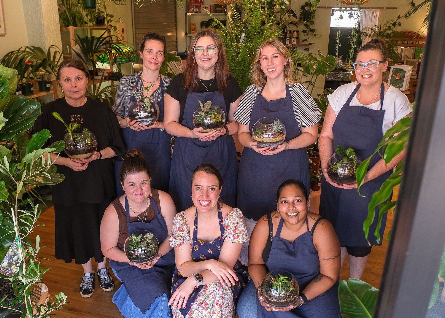 Group of smiling women who have made their terrariums.